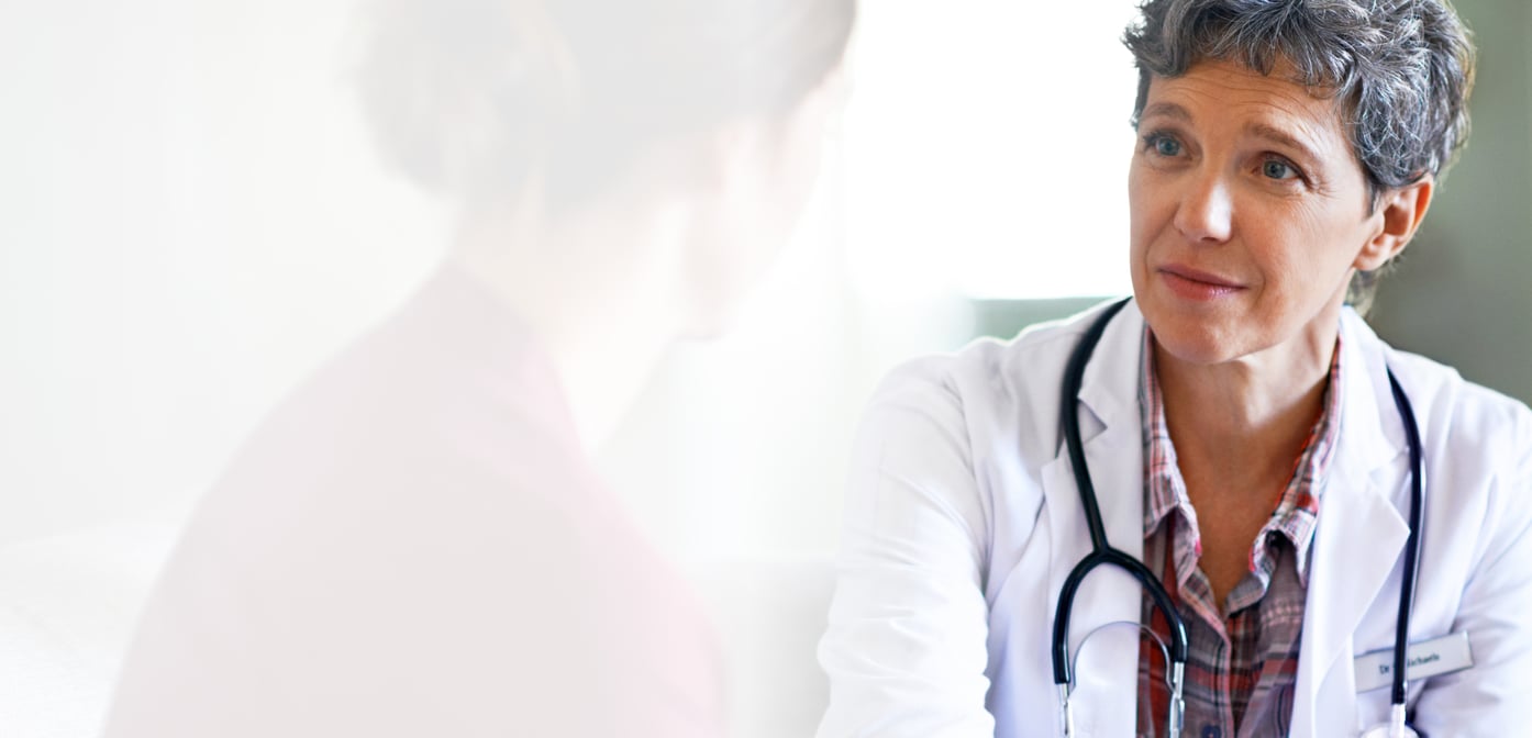 Caring doctor speaks with female patient